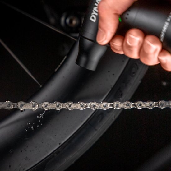 Een hand houdt de zwarte 'Airforce Max' blower dichtbij een fietsketting.