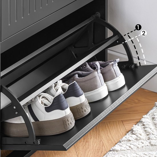 Onderste klep van een zwarte schoenenkast, open met witte en grijze sneakers.