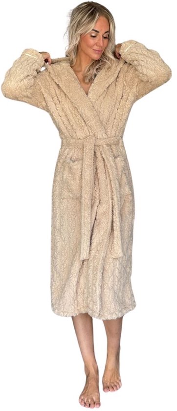 Lange beige badjas met capuchon van zacht fleece, model staat, handen bij capuchon.