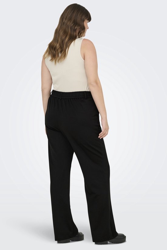 Een model van achteren gezien in een zwarte wijde broek met elastische tailleband.