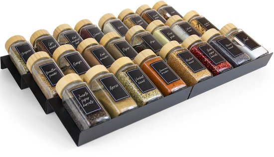 Een zwart kruidenrek gevuld met vele kruidenpotjes met houten deksels, labels leesbaar.