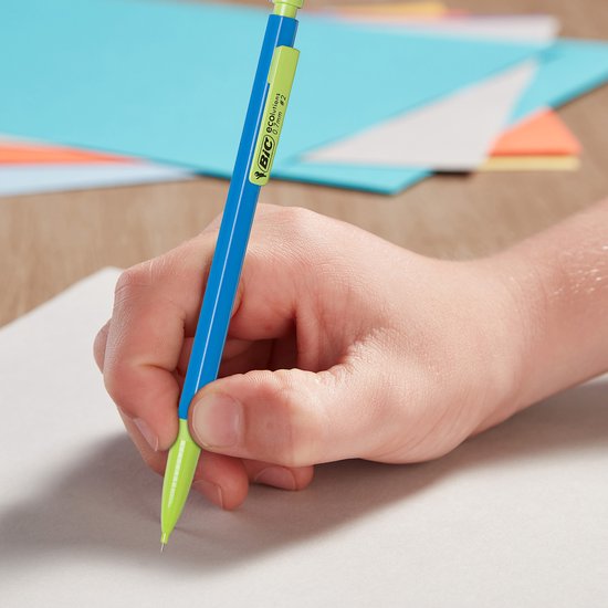 Hand gebruikt een blauw BIC ECOlutions vulpotlood met limegroene punt en clip om te schrijven op wit papier.