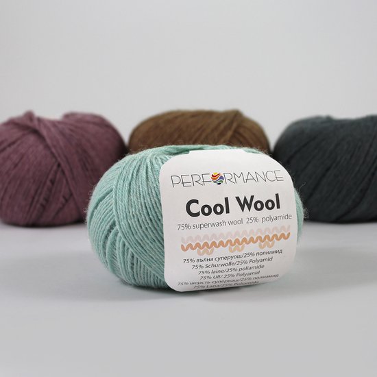 Pelote de fil vert menthe Cool Wool de Performance, avec d'autres pelotes à l'arrière.