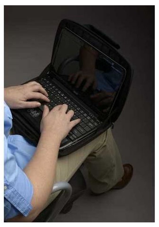 Persoon typt op laptop in zwarte sleeve, die op schoot rust.
