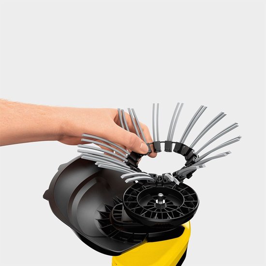 Hand met de borstelkop van de Kärcher onkruidverwijderaar, met grijze kunststof borstelharen.