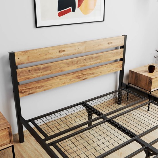 Houten hoofdbord met 3 planken en zwart metalen frame van een bed.