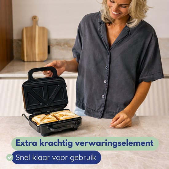 Vrouw plaatst broodjes in een open zwart tosti-apparaat. Extra krachtig verwarmingselement.