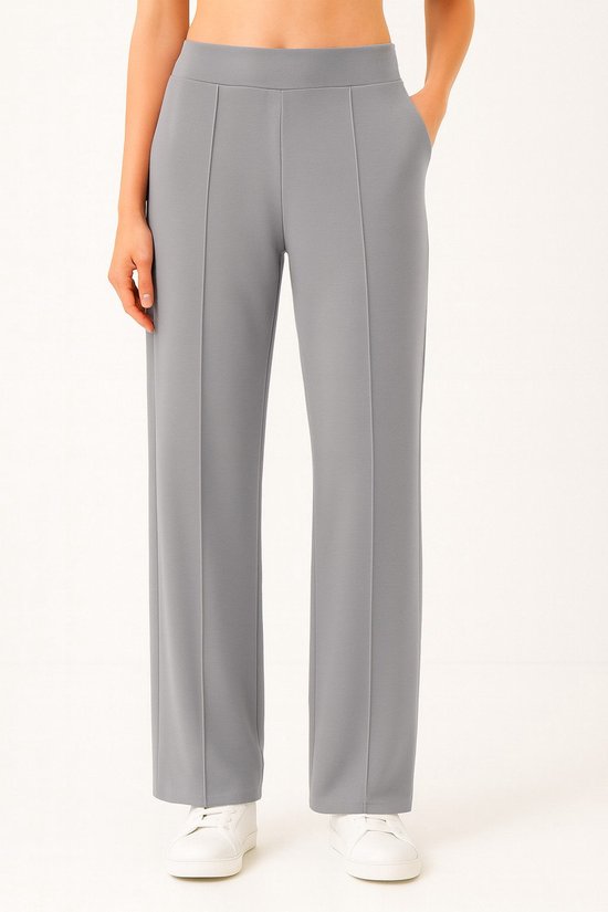Grijze joggingbroek met rechte pijp, naden aan de voorkant en zakken, gedragen door een model.