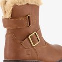 Detail van bruine biker boot met ritssluiting, gouden gesp en beige bontkraag.