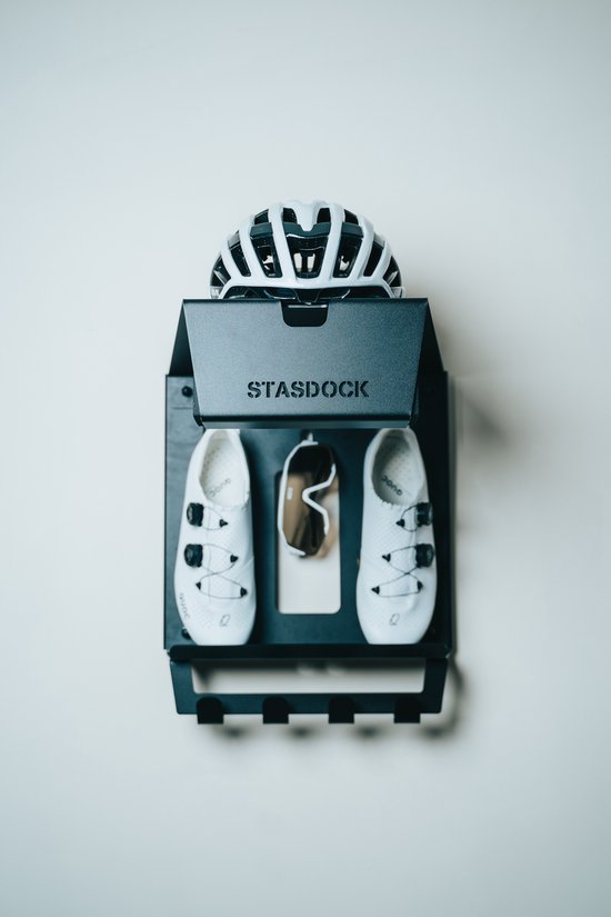 Zwarte Stasdock fietsbeugel met witte fietsschoenen, witte helm en oranje fietsbril.