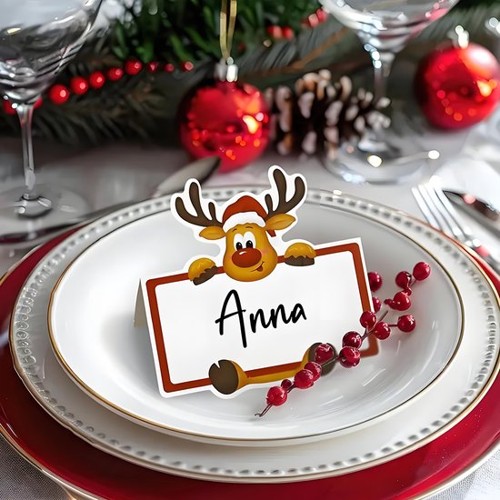 Rendier naamkaartje met de naam 'Anna' op een gedekte kersttafel, versierd met rode bessen.