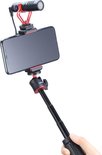 Telefoon met microfoon op een selfiestick, vastgehouden door een hand.