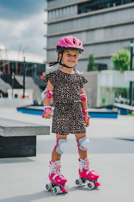 Meisje met roze helm, pols-, elleboog- en kniebeschermers, op roze skeelers.