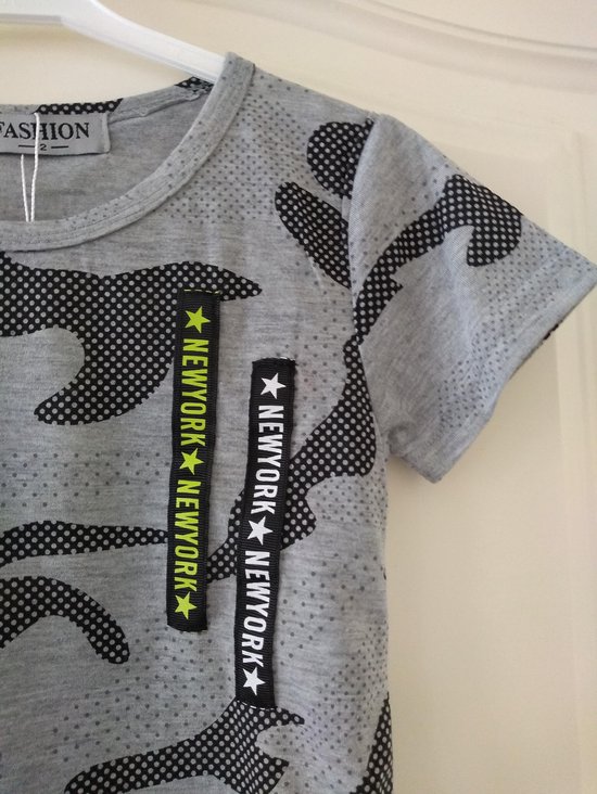 Detail van grijs T-shirt met camouflageprint en twee zwarte banden met 'NEW YORK' in het geel en wit.