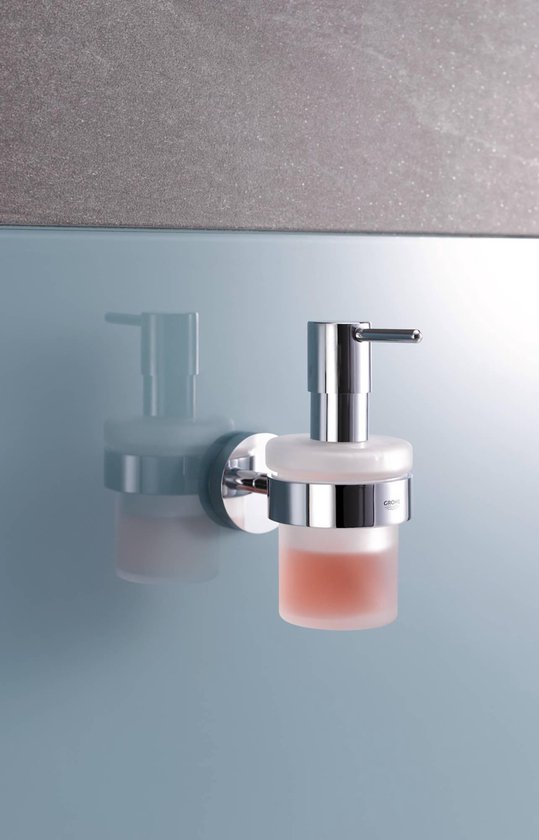 Chroom zeepdispenser met glazen reservoir, gevuld met roze zeep.