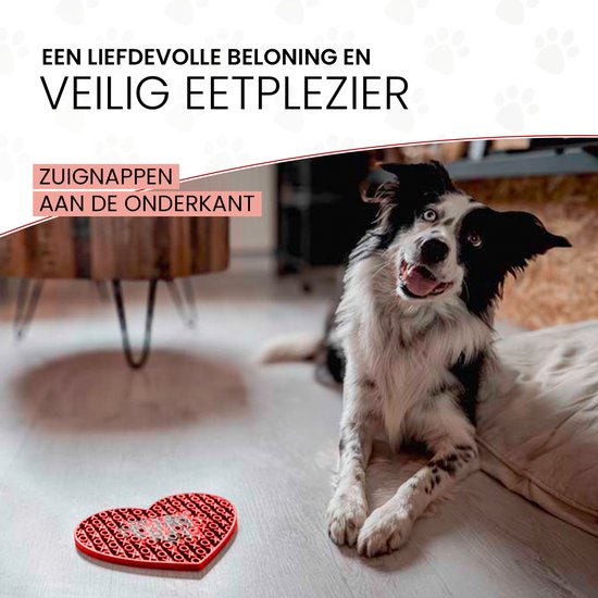 Rode hartvormige likmat op een lichte vloer, met een border collie op de achtergrond.