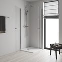 Badkamer met glanzend chromen douchesysteem, grote douchekop, handdouche en thermostaatkraan in een glazen douchecabine.
