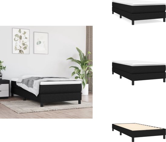 Zwart boxspringbed met witte matrastopper, opgemaakt in een slaapkamer.