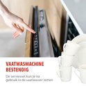 Een hand die een vaatwasmachine bedient, met op de voorgrond een stapel witte mokken.
