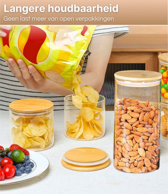 Mains versant des chips d'un sac dans un bocal en verre. À côté de bocaux contenant des chips de pommes de terre et des amandes.