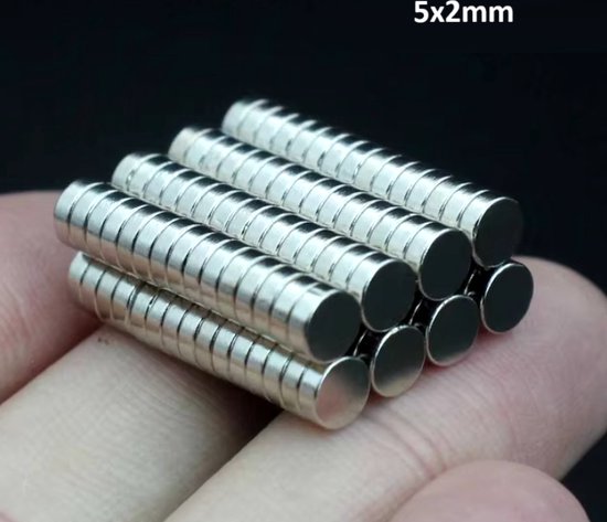 Een hand houdt een stapel cilindrische, zilverkleurige magneten vast met de tekst 5x2mm.
