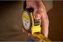 Hand houdt Stanley Tylon rolbandmaat vast, 5m, met uitgetrokken lint.