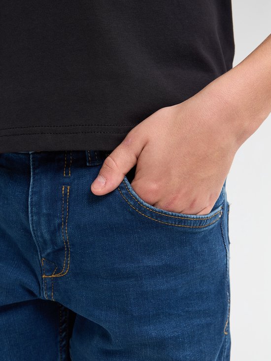 Gedetailleerde opname van de zak van een jongen in een blauwe jeans.