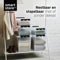 Transparante stapelbare opbergboxen met zwarte clips, gevuld met textiel en kleding.