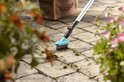 GARDENA voegenborstel met metalen borstelharen op een terras tussen planten