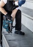 Man gebruikt een Bosch boorhamer op een betonnen ondergrond.