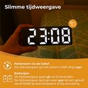 Hand die een zwarte digitale wekker vasthoudt met witte cijfers die 23:08 tonen. Tekst: Slimme tijdweergave.