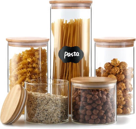 Ensemble de bocaux de stockage en verre avec couvercles en bambou, remplis de pâtes, céréales, bonbons et collations. Un couvercle est à côté.