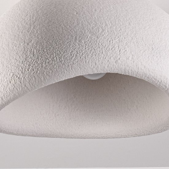 Close-up van de witte, gestructureerde binnenkant van de lampenkap van de plafondlamp.
