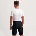 Man met wit Rogelli fietsshirt en zwarte fietsbroek, gezien van achter.