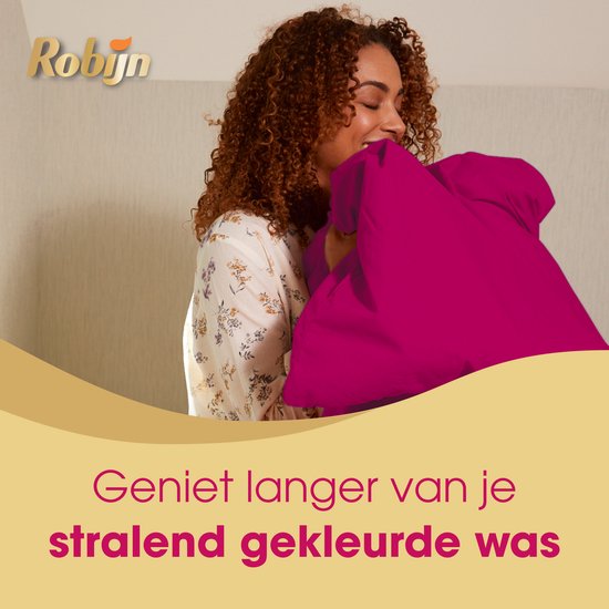 Femme aux cheveux bouclés enfouissant son visage dans un coussin rose vif. Texte : Profitez plus longtemps de votre linge aux couleurs éclatantes.