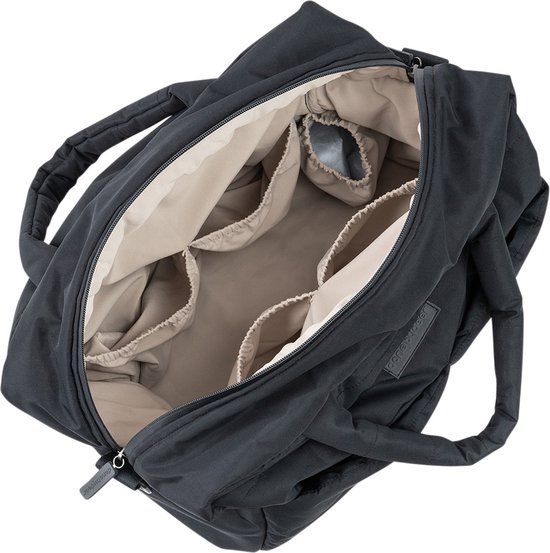 Sac à langer noir ouvert avec plusieurs compartiments à l'intérieur.