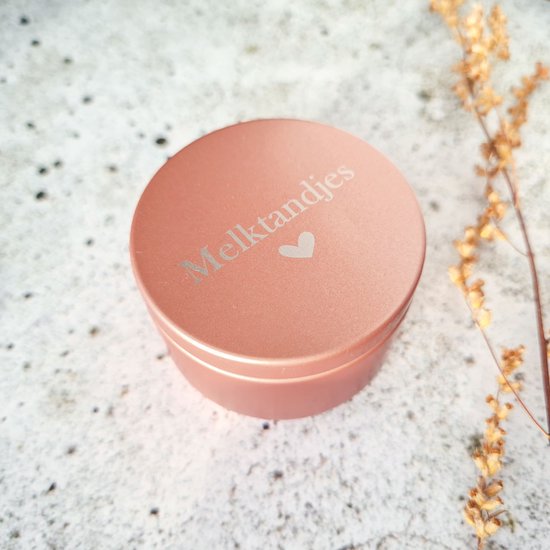 Roze blikje met 'Melktandjes' en een hartje erop gegraveerd.
