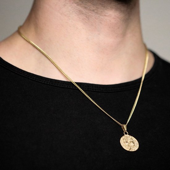 Gouden ketting met muntvormige hanger, gedragen door een man in een zwart T-shirt.