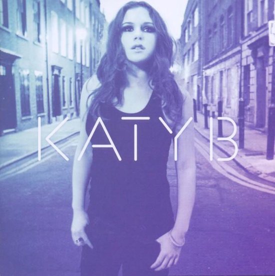 Katy B in een zwart tanktop en zwarte broek, staand op een straat. Gele tekst "KATY B" met paarse gloed.