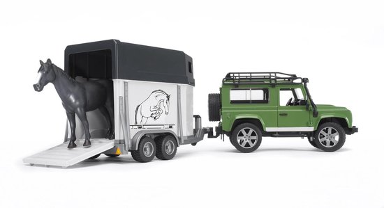 Groene Land Rover met open paardentrailer. Een donkerpaars paard staat op de laadklep.
