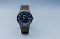 Zwart horloge met blauwe wijzerplaat, zilveren indexen en datum. De wijzerplaat heeft een subtiel kleurverloop van licht naar donker blauw. Milanese band.