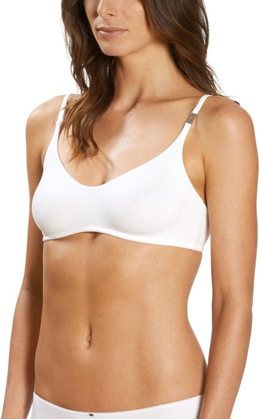 Model draagt witte beugel bh met verstelbare gouden detail op bandjes.