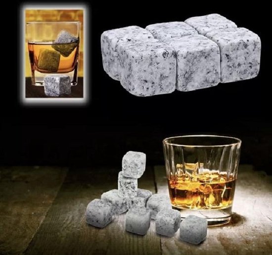 Zes kubusvormige whisky stenen met grijs gespikkeld patroon, naast een glas whisky.