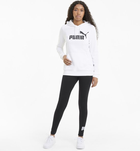 Model in witte hoodie en zwarte legging met Puma logo op de zijkant van de broekspijp.