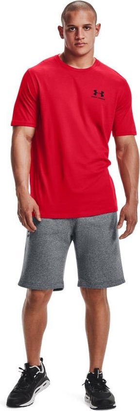 Man draagt rood Under Armour sportshirt en grijze korte broek.