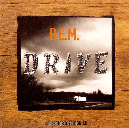 R.E.M. DRIVE Collector's Edition CD met een vrachtwagen op de achtergrond.