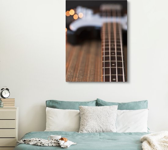 Une guitare basse repose sur le sol Toile 120x160 cm - Tirage photo sur toile (Décoration murale salon / chambre) XXL / Groot format!