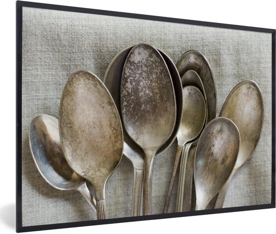Une collection de cuillères rouillées et antiques de tailles variées. Ces cuillères sont placées sur une toile de lin uniforme 60x40 cm