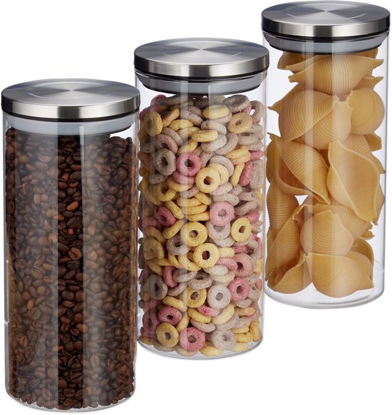 Drie glazen voorraadpotten met RVS deksels, gevuld met koffiebonen, ontbijtgranen en pasta.