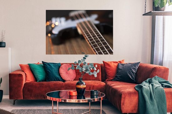Une guitare basse repose sur une table Poster 120x80 cm - Tirage photo sur Poster (décoration murale salon / chambre)